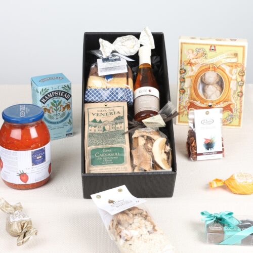 Geschenkbox mit italienischen Spezialitäten wie Risottoreis, Kohl-Saft, Gebäck, Pilzen und einem Glas Tomaten.